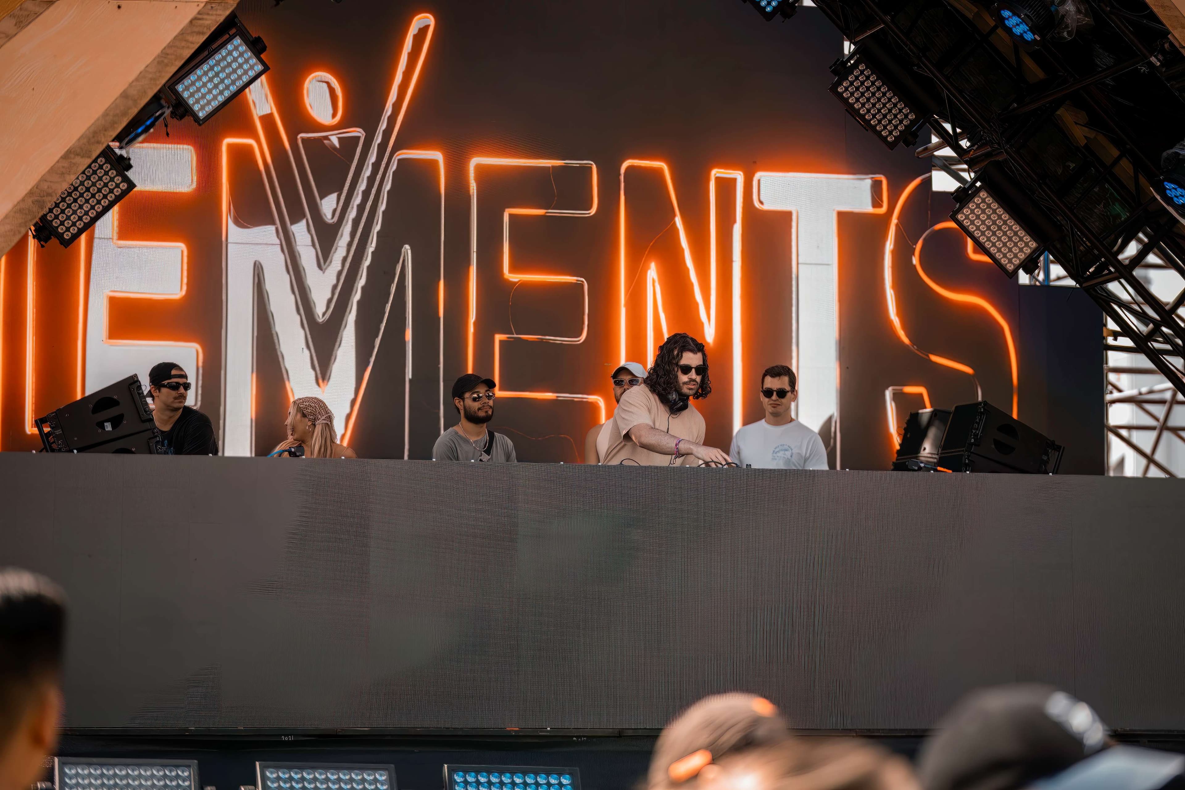 a group of people standing in front of a stage with the words elements on it