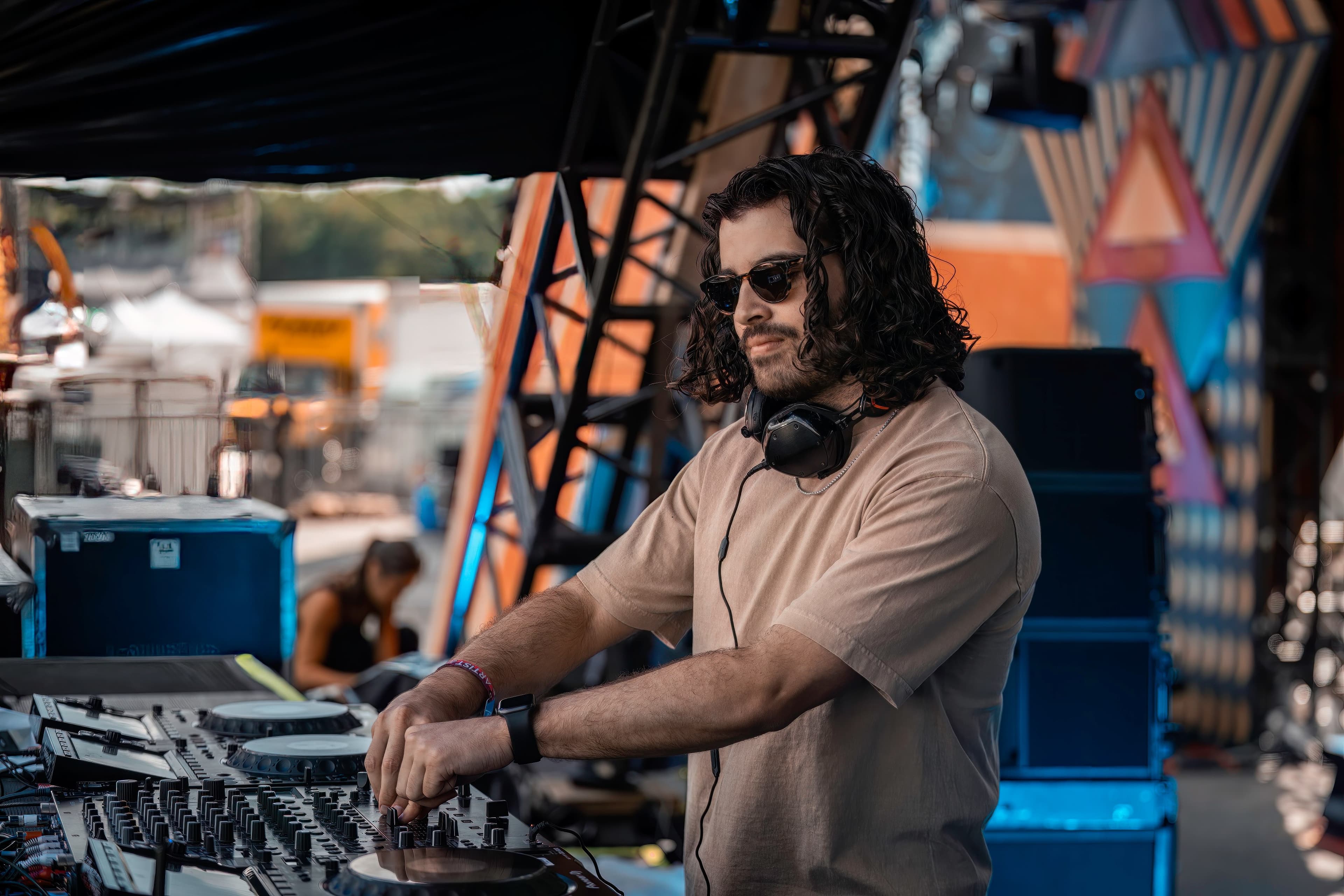 a man with long hair and sunglasses is djing at a festival