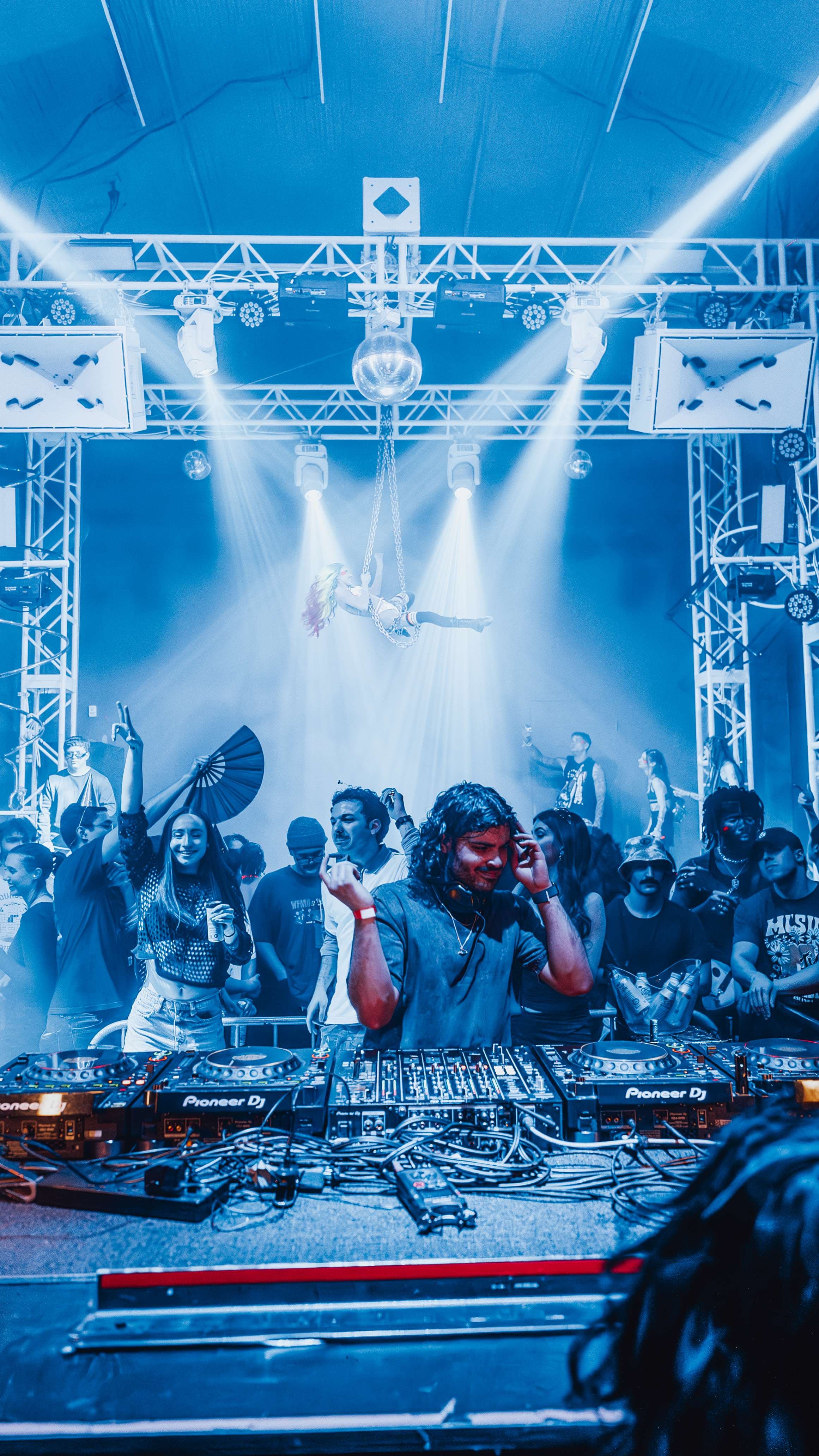 a group of people standing in front of a dj booth